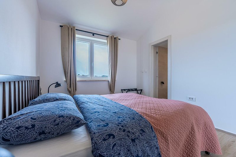Modernes Schlafzimmer mit stilvoller Beleuchtung, elegantem Holzbett und gemütlicher Bettwäsche.