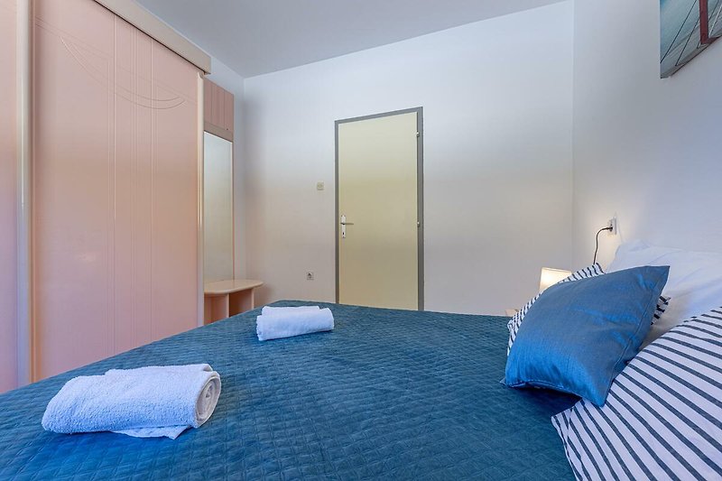 Gemütliches Schlafzimmer mit blauer Inneneinrichtung und Holzmöbeln.