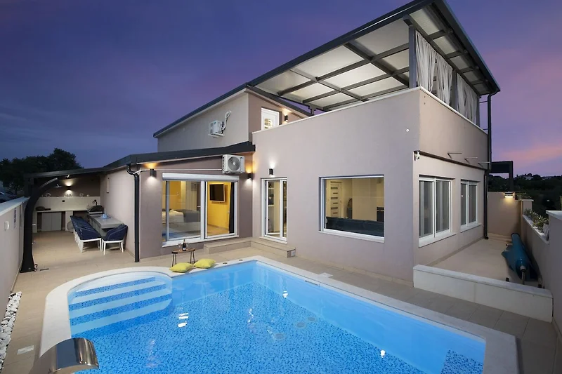 Pool und Villa in gepflegter Resortkulisse.