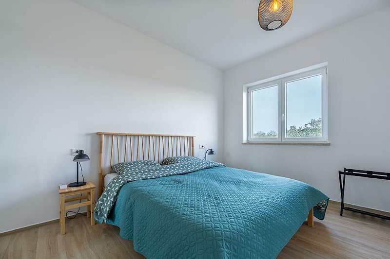 Modernes Schlafzimmer mit elegantem Holzbett, stilvoller Beleuchtung und gemütlicher Bettwäsche.