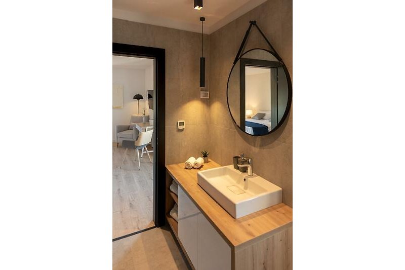 Stilvolles Badezimmer mit elegantem Waschbecken und Spiegel.