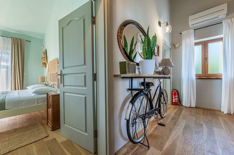 Gemütliches Zimmer mit Fahrraddekor und Pflanzen.