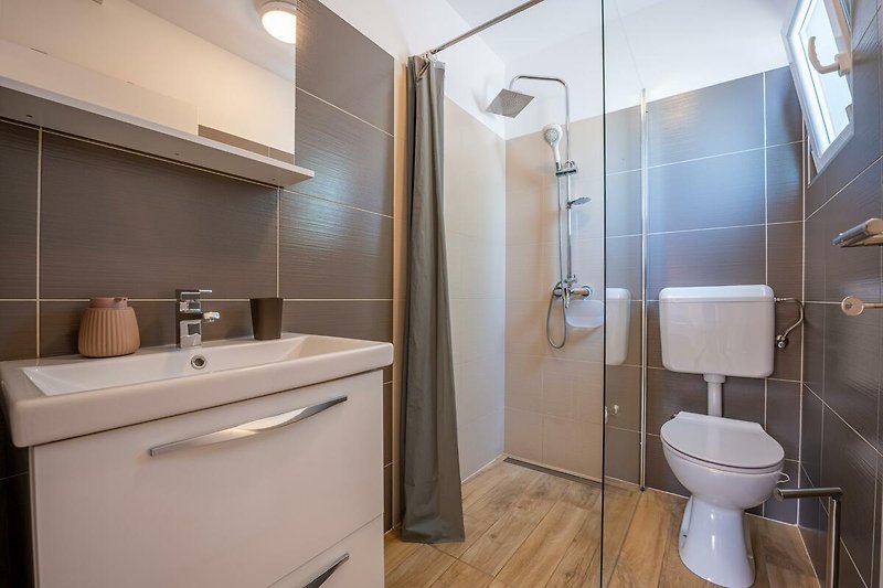 Modernes Badezimmer mit lila Akzenten und stilvoller Einrichtung.