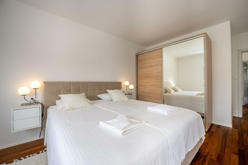 Willkommen in diesem stilvollen Schlafzimmer mit gemütlichem Bett und stilvollem Interieur. Entspannen Sie und genießen Sie den Komfort.