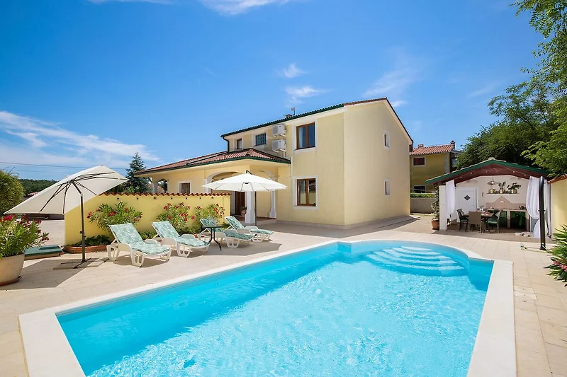Poolterrasse der Villa mit Lounge-Bereich am Wasser