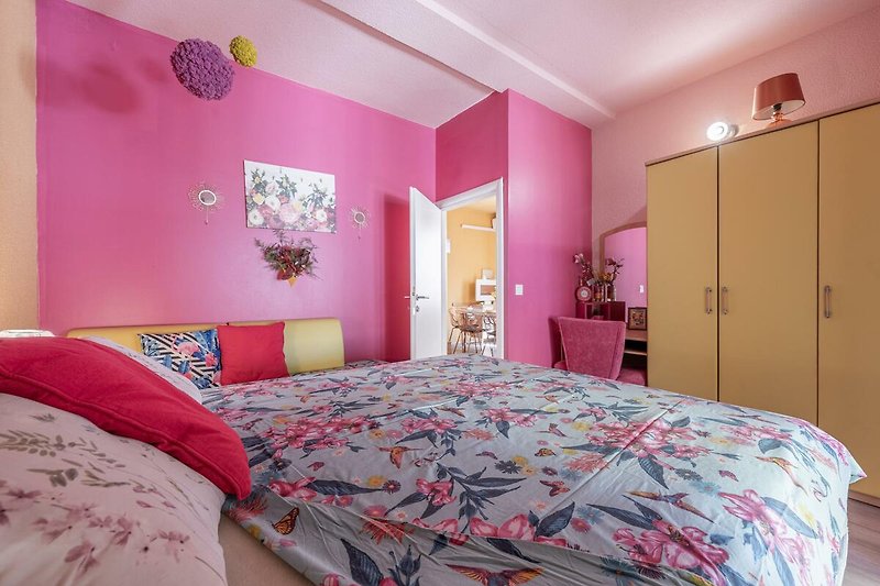 Gemütliches Schlafzimmer mit violettem Bett und schöner Dekoration.