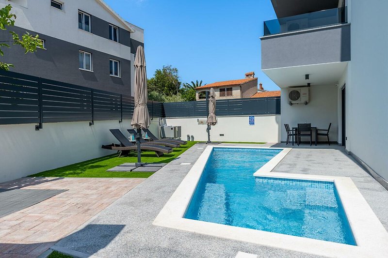 Schwimmbad mit moderner Architektur und azurblauem Wasser. Perfekt für erholsame Ferien.