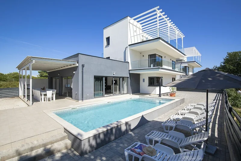 Villa mit Pool, Balkon und stilvollen Outdoor-Möbeln.