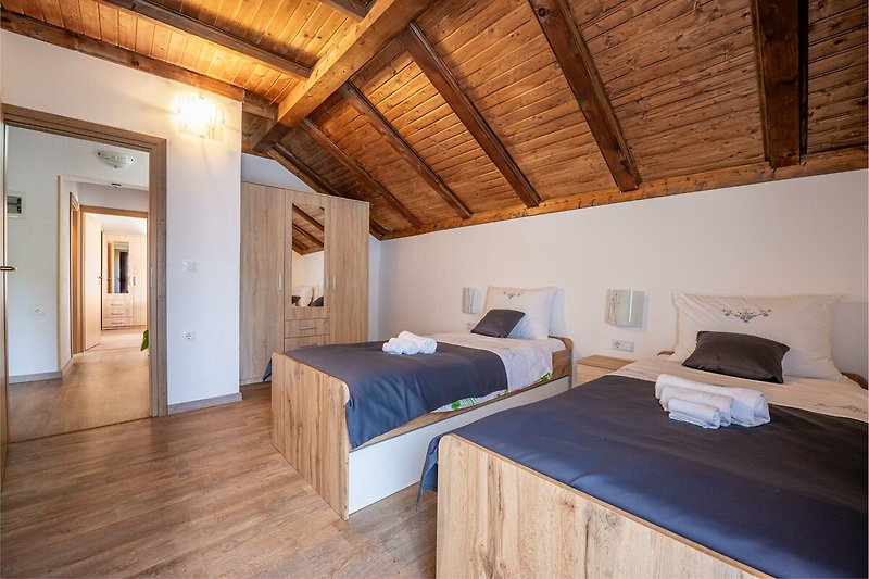 Gemütliches Schlafzimmer mit stilvollem Holzboden und bequemem Bett. Perfekt zum Entspannen und Träumen.