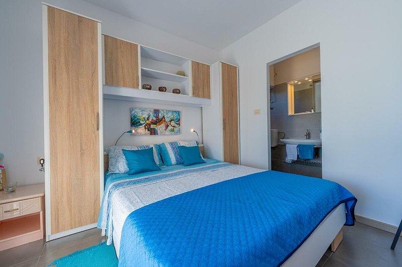 Gemütliches Schlafzimmer mit blauer Inneneinrichtung und bequemem Bett.