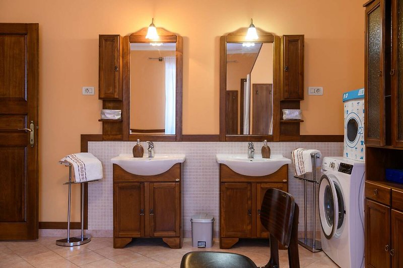 Gemütliches Badezimmer mit Spiegel, Waschbecken und stilvoller Einrichtung.