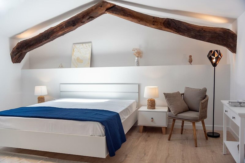 Stilvolles Schlafzimmer mit Holzmöbeln und gemütlicher Beleuchtung.