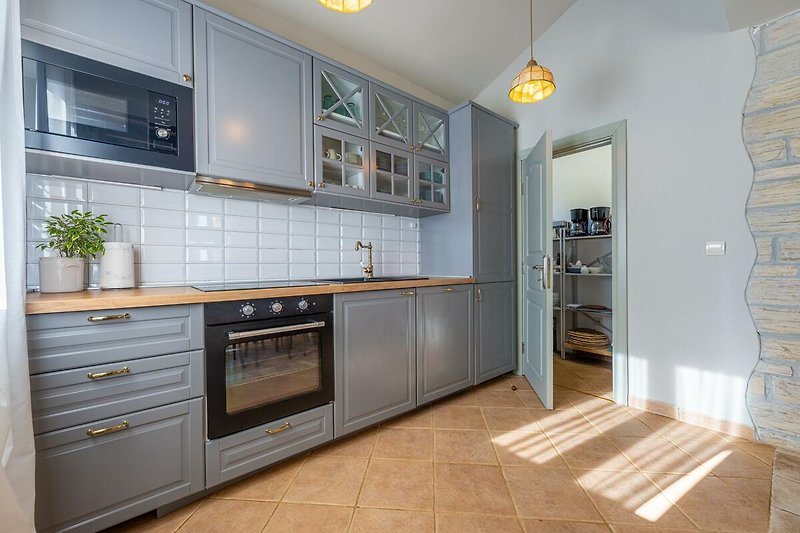 Moderne Küche mit Holzboden, Granit-Arbeitsplatte und Gasherd.