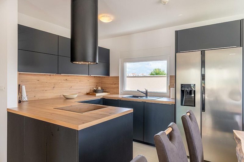 Verbringen Sie Ihren Urlaub in dieser modernen Küche mit stilvollem Design und hochwertigen Geräten.
