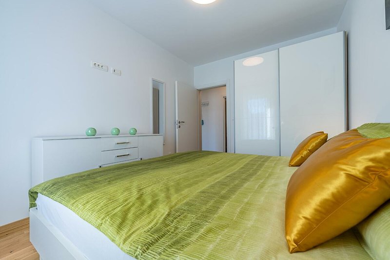 Schlafzimmer mit elegantem Bett, Fenster und stilvoller Einrichtung.