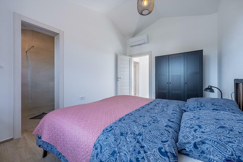 Stilvolles Schlafzimmer mit elegantem Holzbett und gemütlicher Bettwäsche.