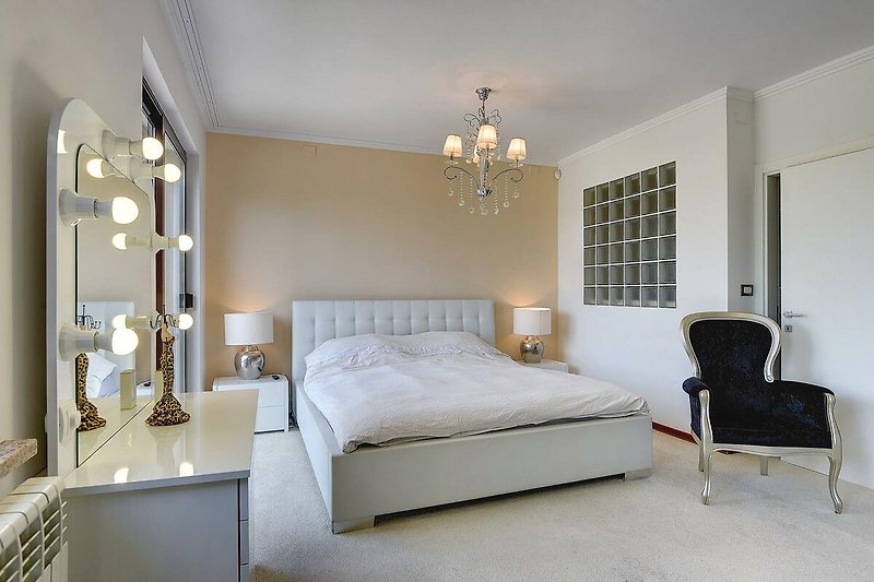 Elegantes Schlafzimmer mit stilvoller Beleuchtung und Holzmöbeln.
