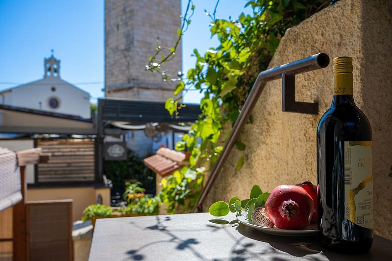 Schöne Aussicht auf die Stadt mit Glasflaschen und Obst. Genießen Sie ein Glas Wein auf der Terrasse.