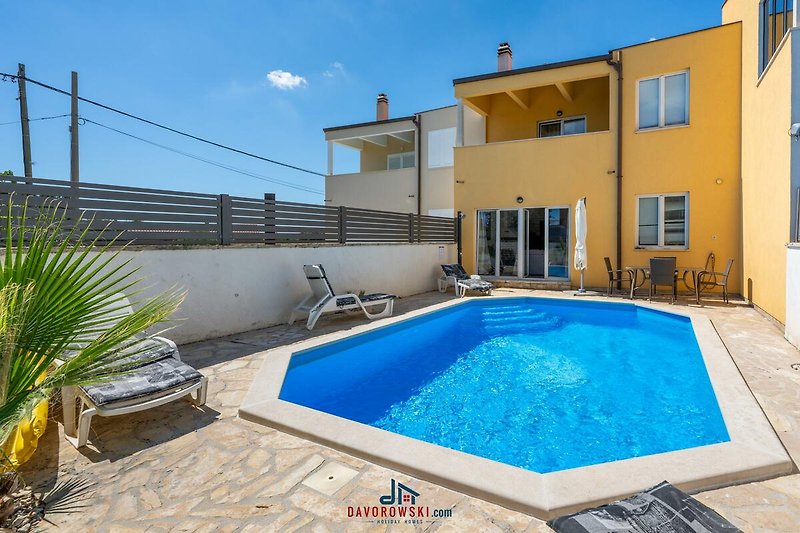 Luxuriöser Pool mit Blick auf den Himmel, umgeben von Pflanzen.