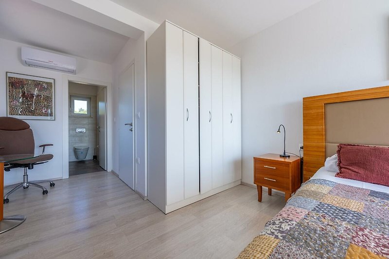 Gemütliches Schlafzimmer mit stilvoller Einrichtung und Holzboden.