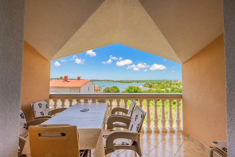 Geräumige Veranda mit Meerblick und Palmen im Hintergrund.