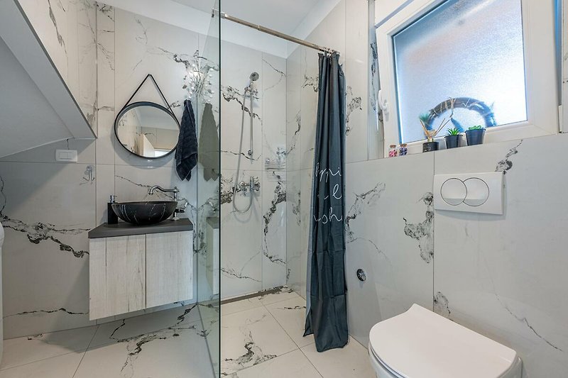 Modernes Badezimmer mit stilvoller Einrichtung und Dusche.