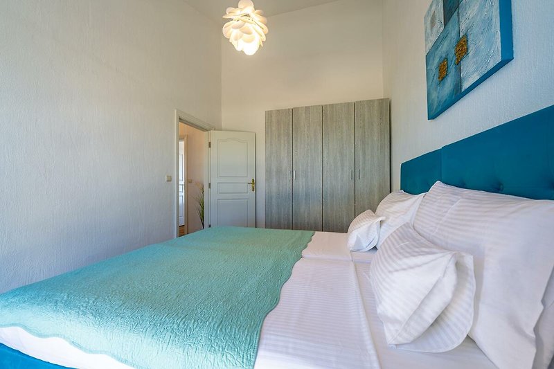 Gemütliches Schlafzimmer mit blauem Bett und stilvollem Interieur.