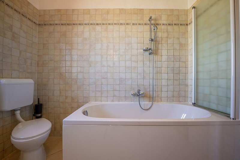 Gemütliches Badezimmer mit lila Badezimmerschrank und Badewanne.