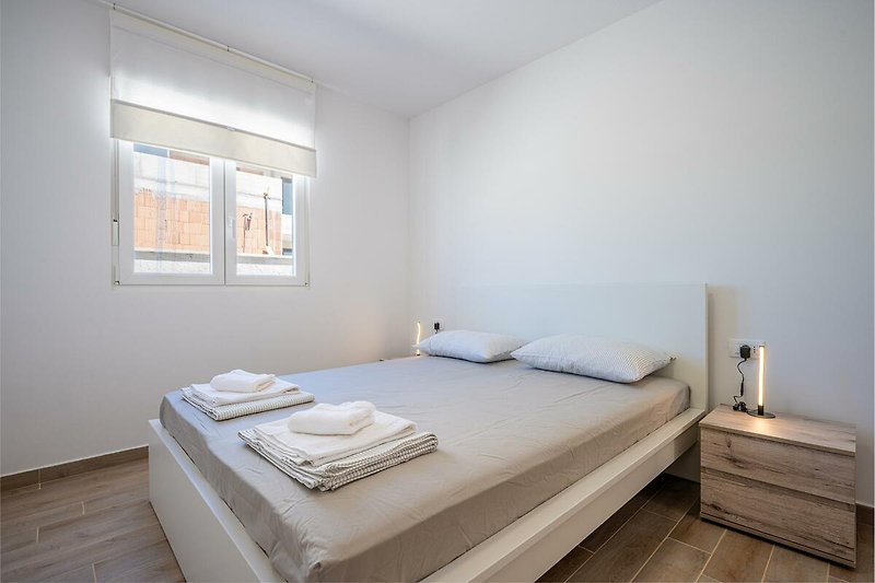 Gemütliches Schlafzimmer mit stilvollem Interieur und bequemem Bett. Perfekt zum Entspannen und Ausruhen.