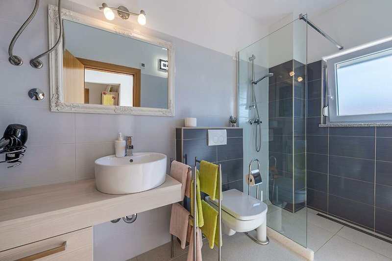 Modernes Badezimmer mit lila Waschbecken und stilvoller Einrichtung.