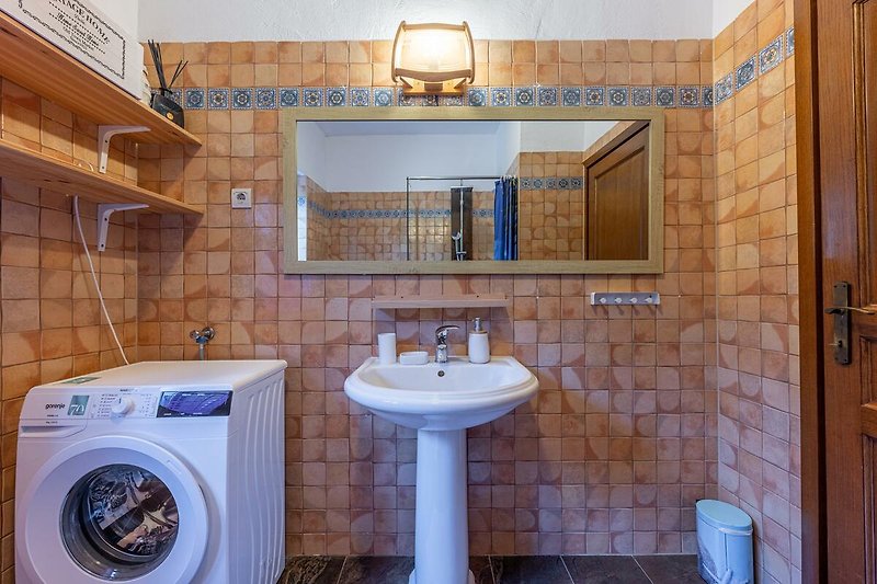 Badezimmer mit lila Waschbecken, Spiegel und Armatur.