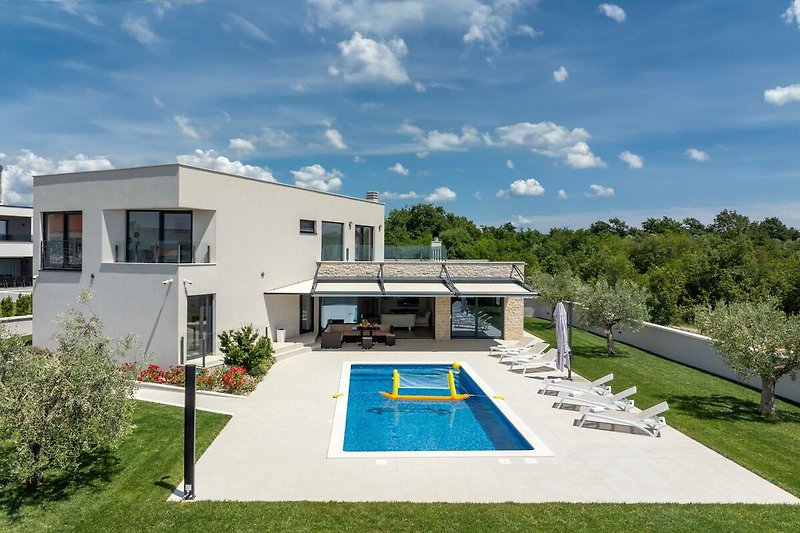 Luxuriöse Villa mit Pool, Garten und moderner Architektur.