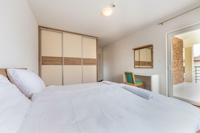 Verbringen Sie eine erholsame Nacht in diesem komfortablen Schlafzimmer mit stilvollem Holzmobiliar und gemütlicher Beleuchtung.