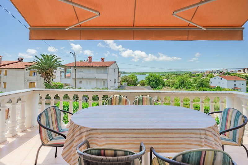 Gemütliche Terrasse mit Holzmöbeln und Blick auf den Garten.