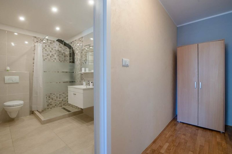 Stilvolles Badezimmer mit Spiegel, Waschbecken und Dusche.