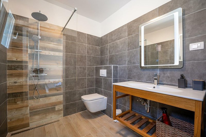 Gemütliches Badezimmer mit stilvoller Ausstattung. Entspannen Sie unter der stilvollen Dusche und genießen Sie den Komfort. Perfekt für einen erholsamen Urlaub!