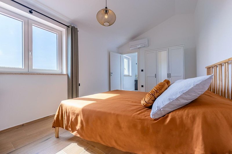 Schlafzimmer mit gemütlichem Bett und Fensterblick.