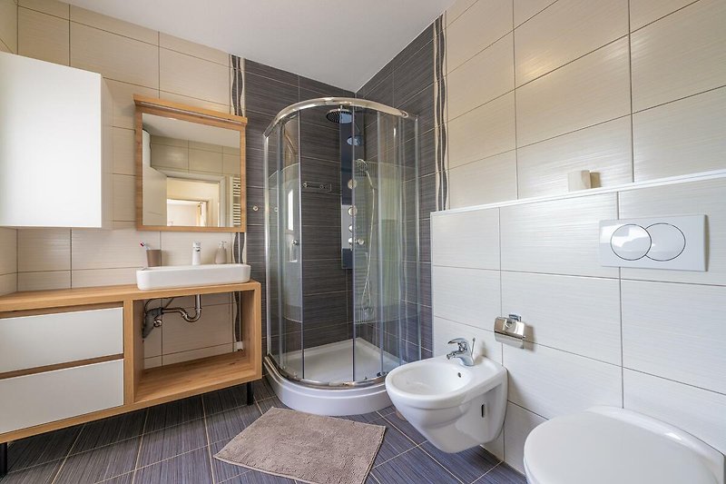 Willkommen in diesem stilvollen Badezimmer mit modernen Armaturen. Entspannen Sie in der Badewanne und genießen Sie den Komfort.