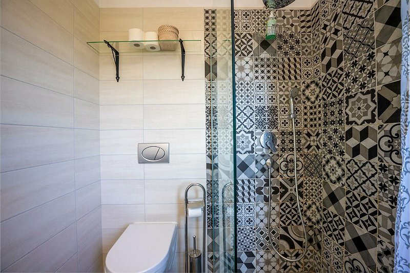 Stilvolles Badezimmer mit rechteckigem Glaswaschbecken und Metallarmatur.
