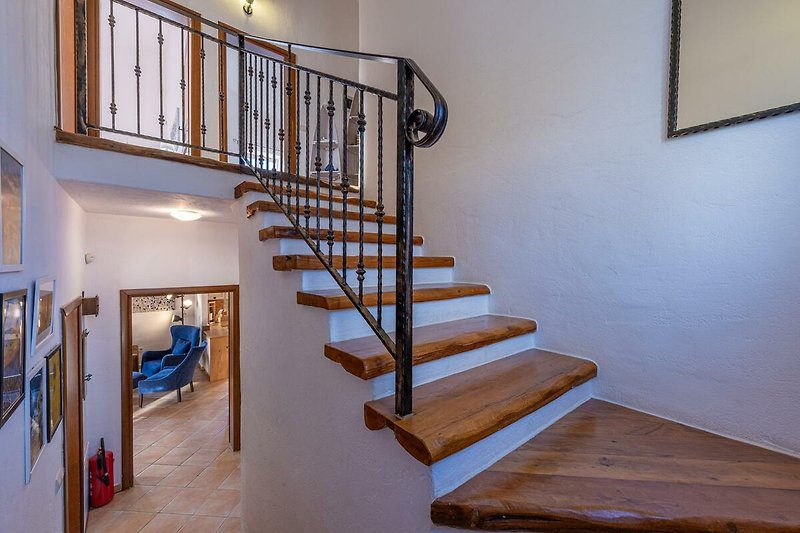 Holztreppe und Geländer in einem stilvollen Innenraum.