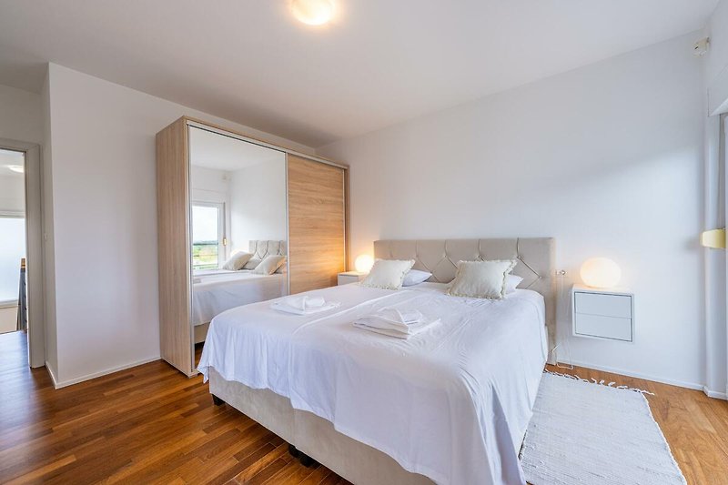 Willkommen in diesem stilvollen Schlafzimmer mit bequemem Bett und stilvollem Interieur. Entspannen Sie und genießen Sie den Komfort.