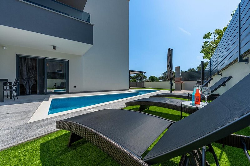 Schönes Haus mit Pool, grüner Umgebung und modernem Design. Perfekt für erholsame Ferien.