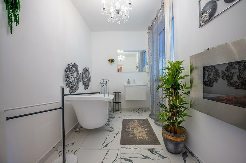 Schönes Badezimmer mit grünen Pflanzen und stilvoller Einrichtung.