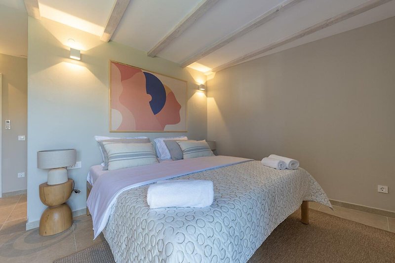 Stilvolles Schlafzimmer mit bequemem Bett und gemütlicher Beleuchtung.
