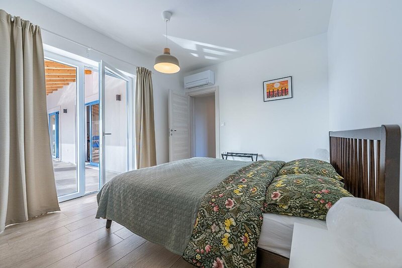 Modernes Schlafzimmer mit stilvollem Holzbett und gemütlicher Bettwäsche.
