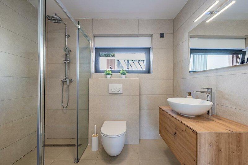 Badezimmer mit lila Akzenten, Spiegel, Toilette und Dusche.