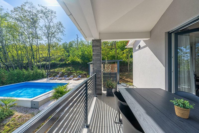 Ein modernes Haus mit Pool, umgeben von Pflanzen und schönem Design.
