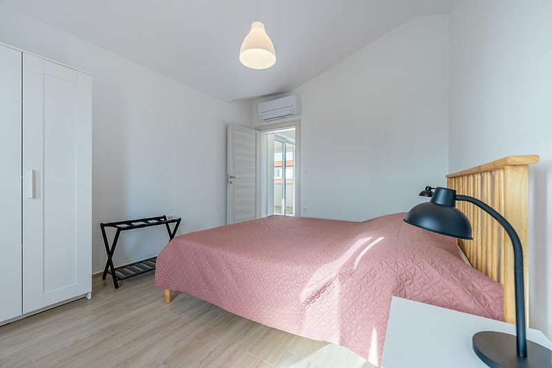 Modernes Schlafzimmer mit stilvoller Beleuchtung und elegantem Holzbett.