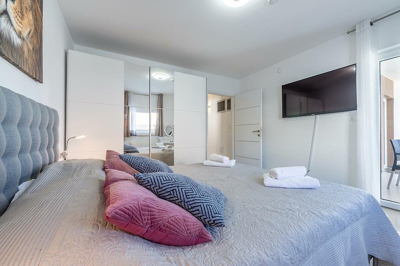 Gemütliches Schlafzimmer mit stilvollem Interieur und Holzmöbeln. Perfekt für einen erholsamen Urlaub.