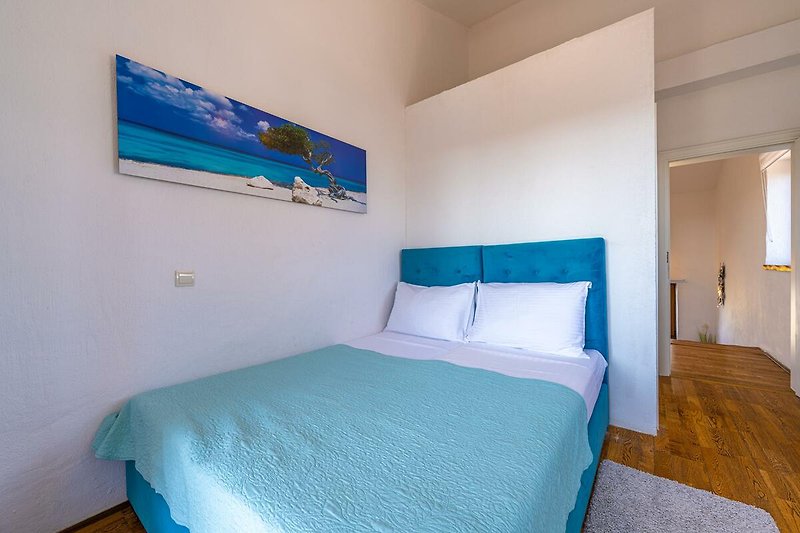 Gemütliches Schlafzimmer mit blauem Bett und stilvollem Interieur.